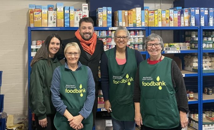 Jason Manford visiting our food bank warehouse with some of our smiling volunteers